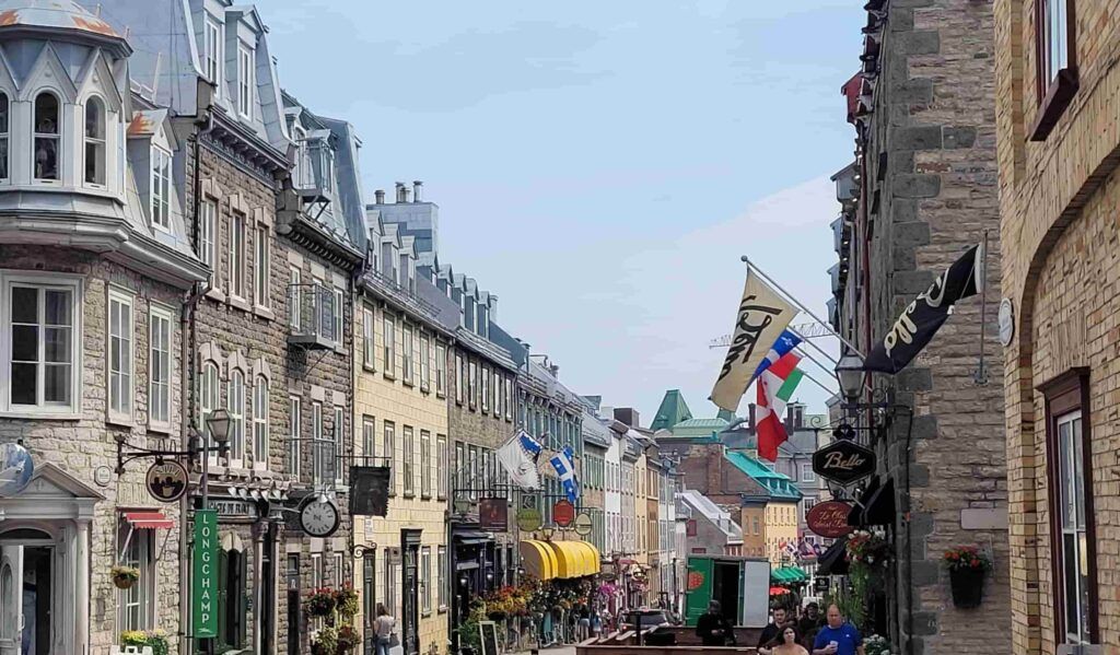 Calle del Viejo Quebec, en Canadá, con edificios de piedra e infinidad de banderas