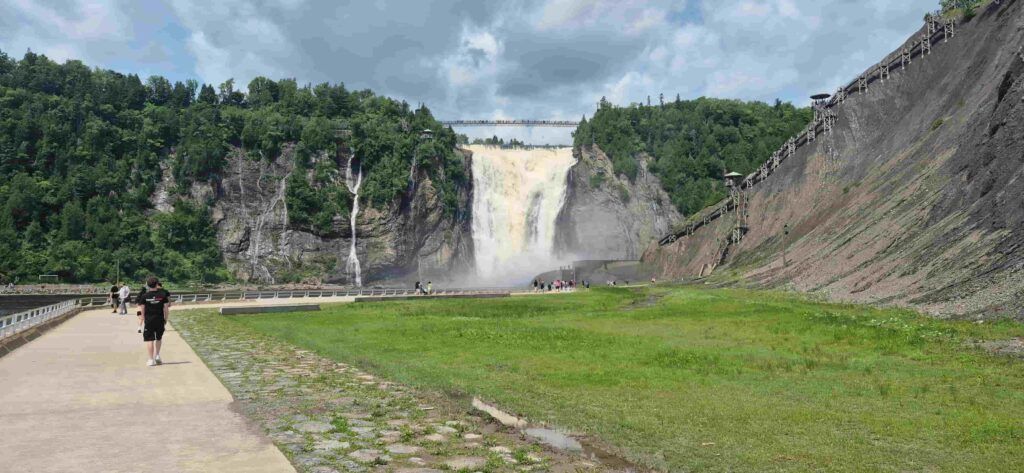Personas dirigiéndose hacia la parte baja de las Cataratas de  Montmorency, en Canadá