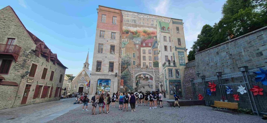 La Fresque des Quebecois en Quebec, Canadá, con la Place Royale al fondo