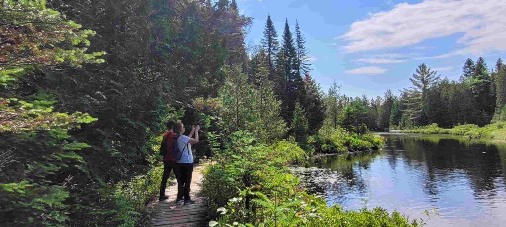 Dos personas contemplando el paisaje en la zona de Les Cascades del Parque La Mauricie en Quebec, Canadá