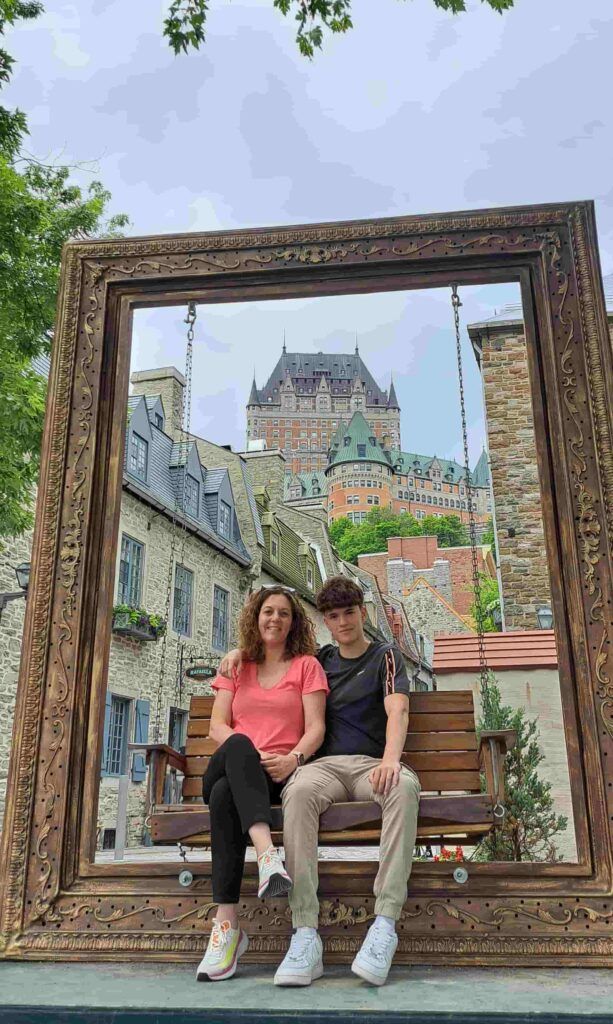 Personas posando en el marco de fotos gigante de Quebec, en Canadá, con el Chateau Le Frontenac al fondo