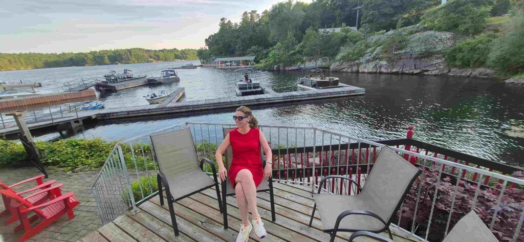 Mujer sentada la terraza trasera de la habitación en el hotel Boathouse Inn, junto al embarcadero de lanchas de Rockport, Canadá, desde 