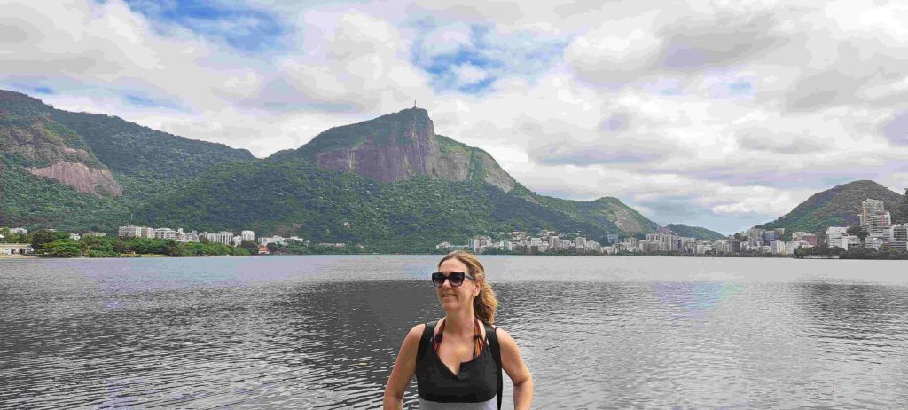 Mujer posando con la Laguna Rodrigo de Freitas a su espalda. Al fondo se divisa el Cristo del Corcovado.
