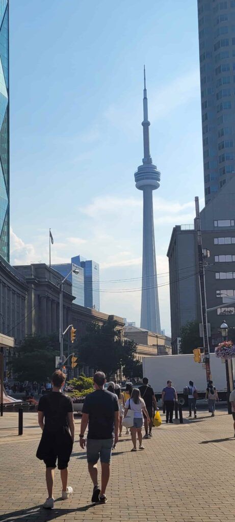 Personas paseando por una calle de Toronto, con la CN Tower al fondo
