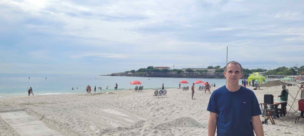 Hombre en la Playa de Copacabana, con el Fuerte de Copacabana al fondo