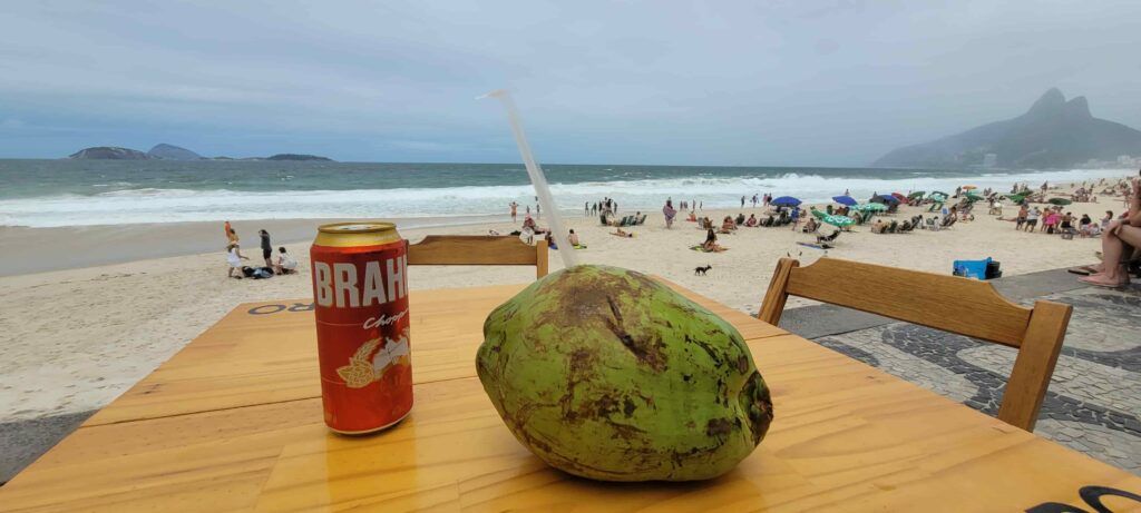 Una mesa con un coco y una cerveza Brahma en la Playa de Ipanema