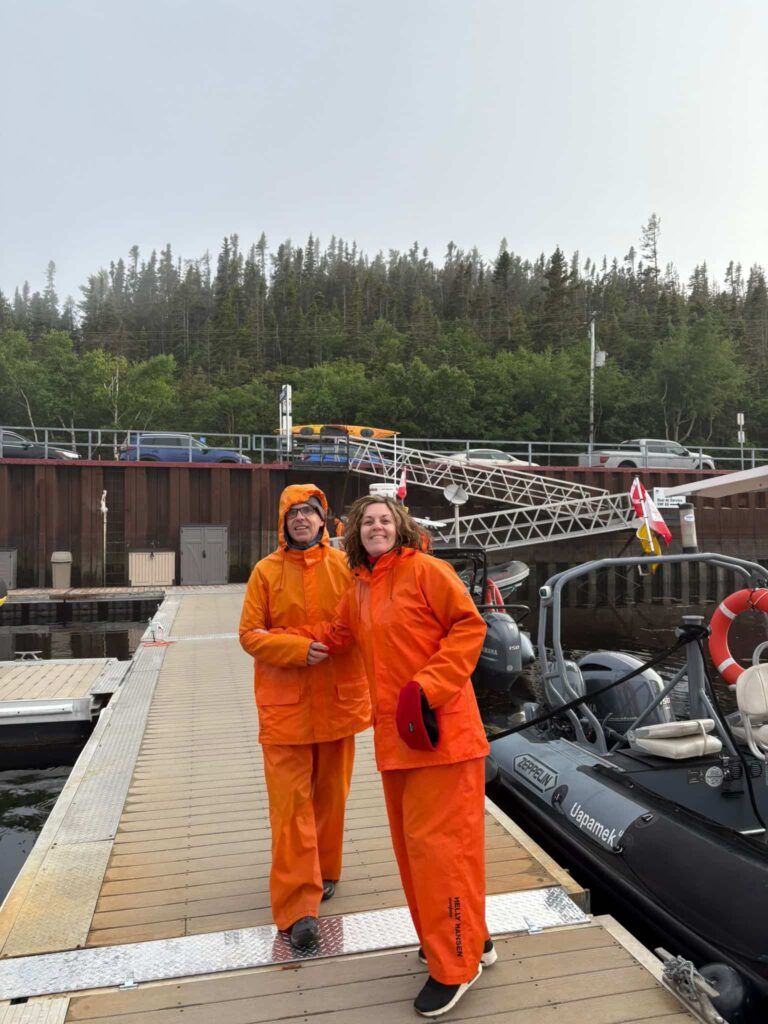 Mujer y hombre vestidos con el traje color naranja de las excursiones para avistar ballenas en Tadoussac, Canadá
