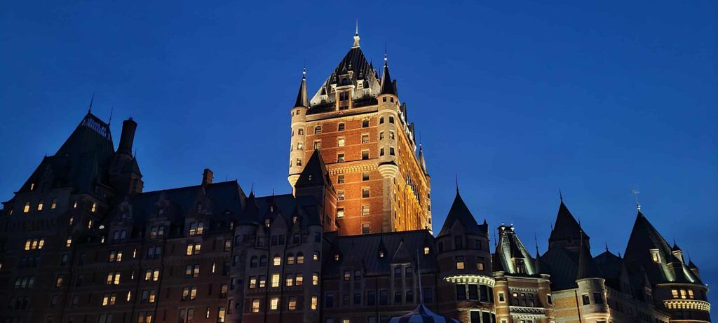 Torre más alta del Hotel Fairmont Chateau Le Frontenac iluminado, al anochecer, en Quebec, Canadá