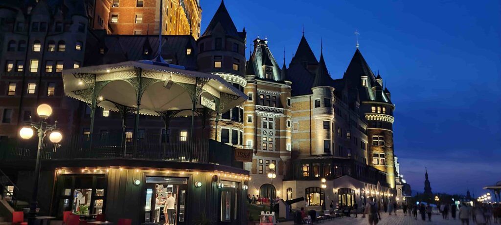 Perspectiva del Hotel Fairmont Chateau Le Frontenac iluminado, al anochecer, en Quebec, Canadá
