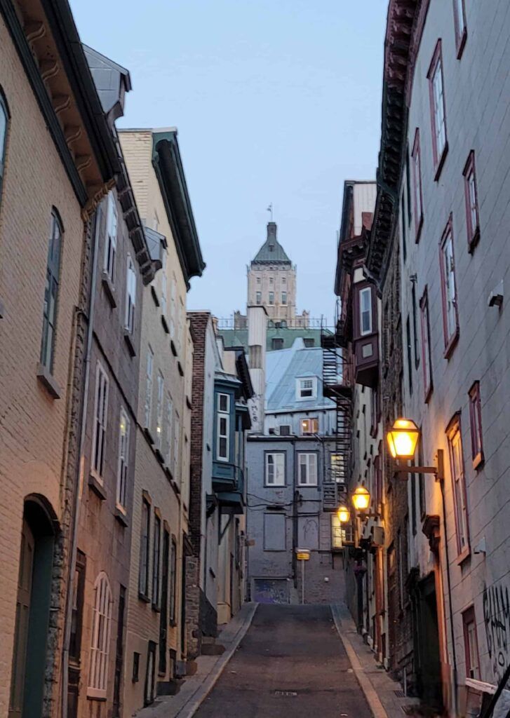 Calle estrecha iluminada al anochecer en Quebec, Canadá