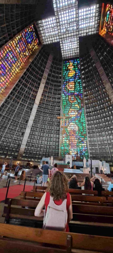 Personas sentadas en los bancos interiores de la Catedral Metropolitana de Río de Janeiro