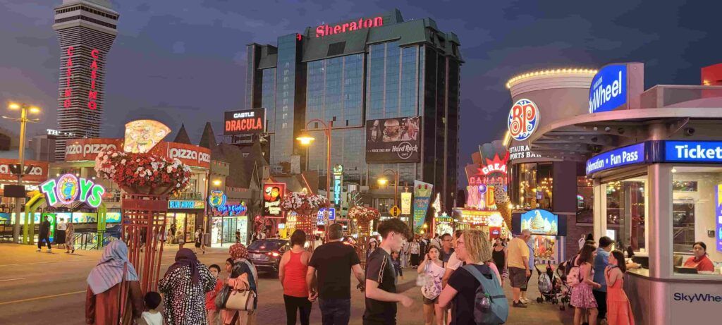 Personas paseando por un animado Clifton Hill de noche, en Niágara Falls, Canadá