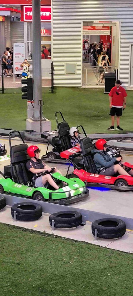 Chicos subidos a coches de carrera en el parque de atracciones de Niágara Falls, Canadá
