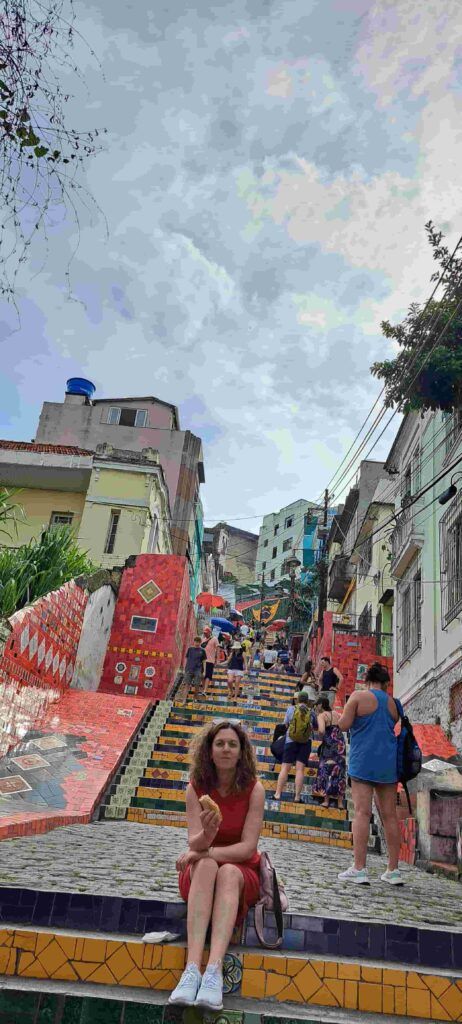 Mujer sentada en las Escaleras de Selaron, comiéndose un bocadillo