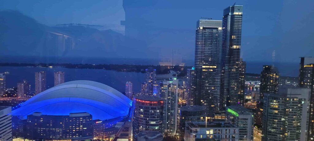 Vista nocturna de rascacielos iluminados en Toronto, desde la terraza del bar restaurante Kost
