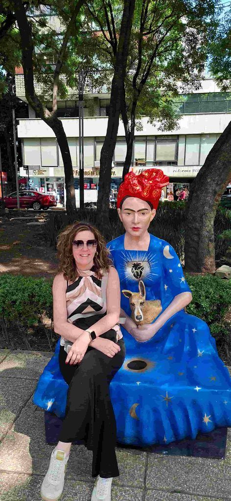 Mujer sentada en un banco con la forma de Frida Khalo en Paseo de la Reforma, CDMX