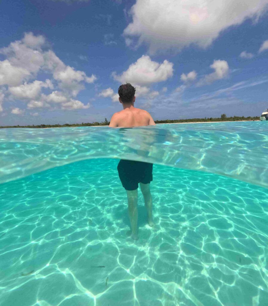 chico de espaldas, bañándose en las transparentes aguas de la playa El Cielito, en la isla de Cozumel