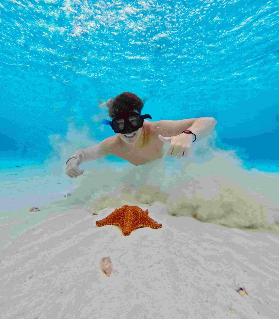 chico buceando junto a una estrella de mar, en la zona El Cielo, en la isla de Cozumel