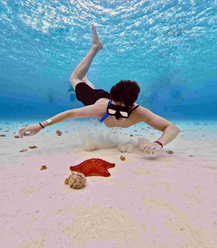 chico buceando junto a una estrella de mar, en la zona El Cielo, en la isla de Cozumel