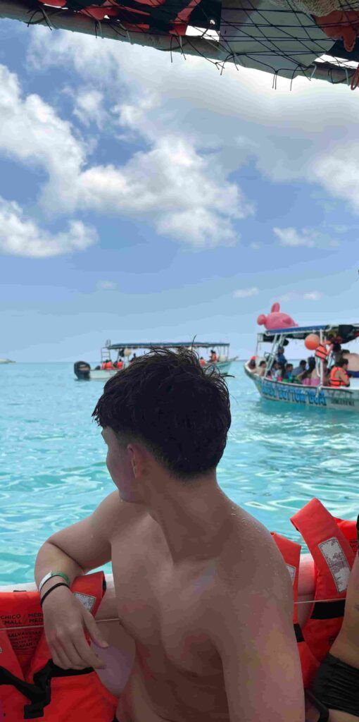 chico subido en lancha en la playa El Cielito, en la isla de Cozumel, México